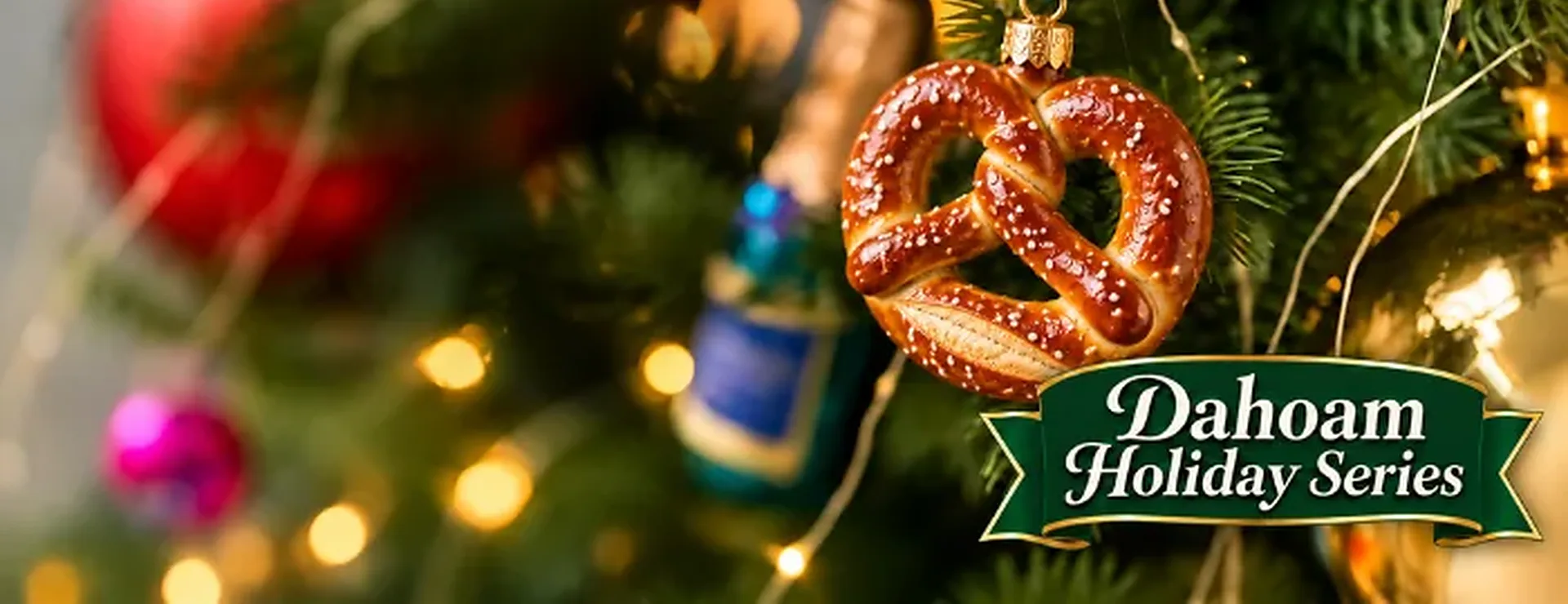 A pretzel ornament on a blue-and-white cord hanging on a lit Christmas tree, with the Dahoam Holiday Series ribbon